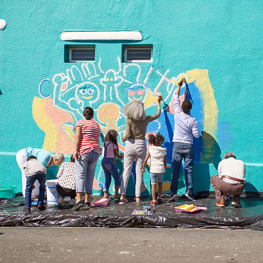 A photo of people working together to paint